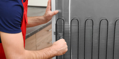 Dirty commercial refrigerator condenser coils being cleaned for better energy efficiency