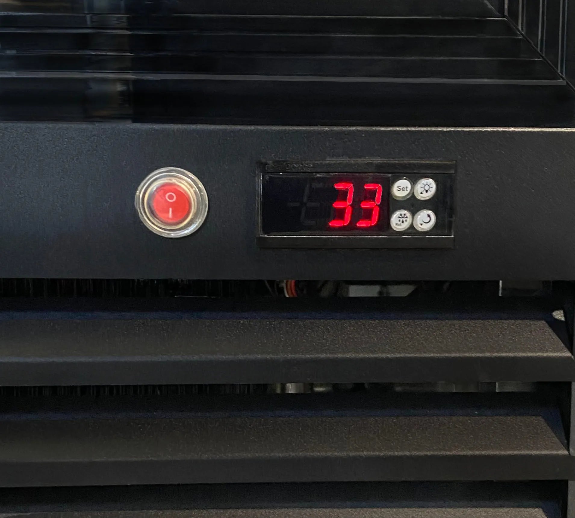 Black electronic device with a digital display showing '33' and a power button.