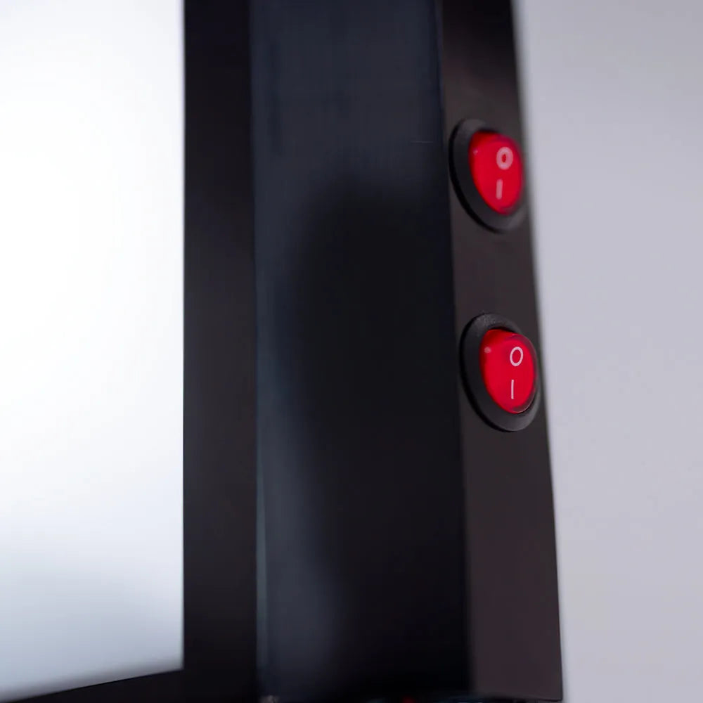Close-up of a black electronic device with red power buttons on a white background