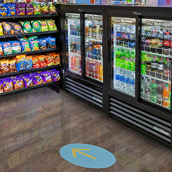 Grocery store interior with refrigerated sections and snack shelves.
