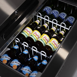 Bottles of beer, including Blue Moon and Rolling Rock, in a cooler.