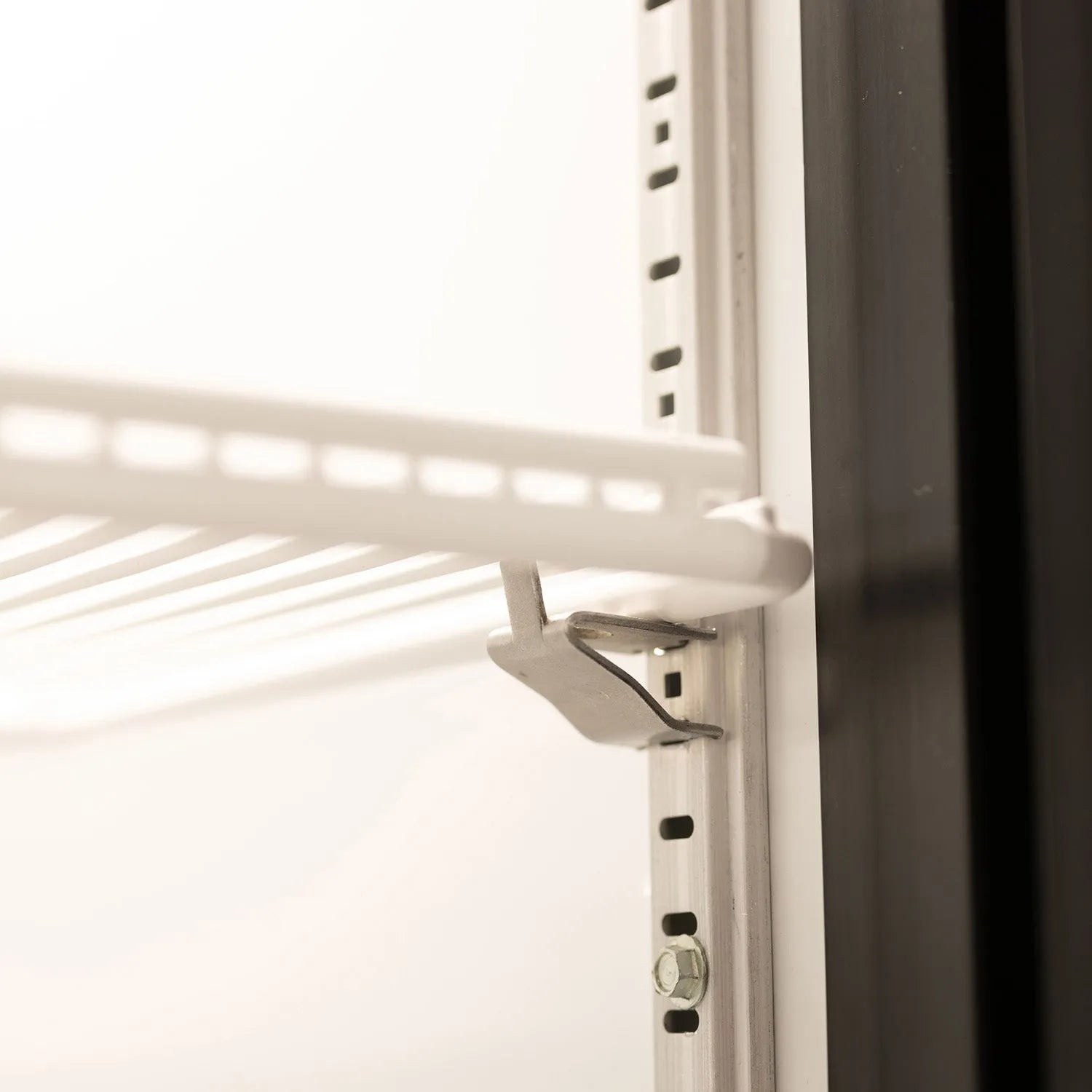 Close-up of a white radiator with a metal bracket on a white background