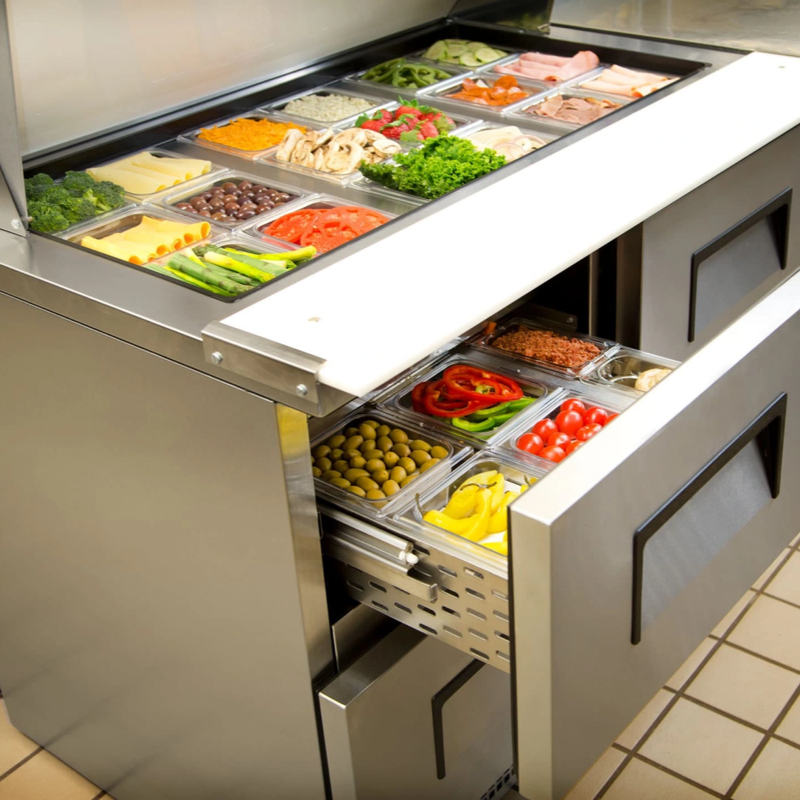 Stainless steel salad bar with various vegetables in compartments.