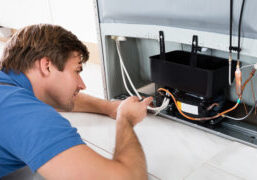 Repair person fixes commercial refrigerator under warranty.